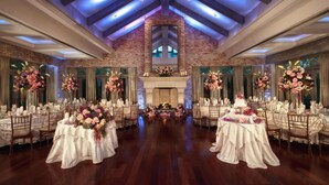 A banquet hall with a brick fireplace, wooden beams, and floral centerpieces. - The Inn At Fox Hollow Hotel (Woodbury)