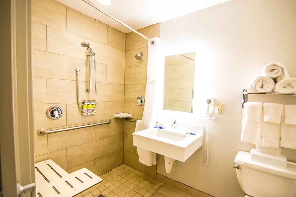 Une salle de bain équipée d’une douche, d’un lavabo, de toilettes et d’un sèche-mains.