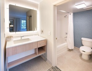 A modern bathroom with a large mirror, a sink, a shower, and a toilet. - Homewood Suites by Hilton Atlanta Buckhead Pharr Road (Atlanta)