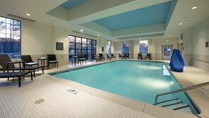 Une piscine intérieure dotée de chaises longues et d’un espace abrité.