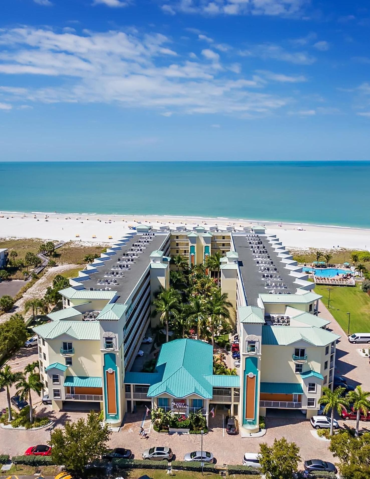 A hotel with a central courtyard, multiple floors, and a beach view.