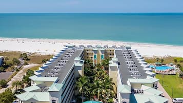 A hotel with a central courtyard, multiple floors, and a beach view.