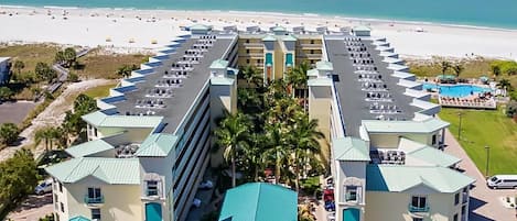 A hotel with a central courtyard, multiple floors, and a beach view.