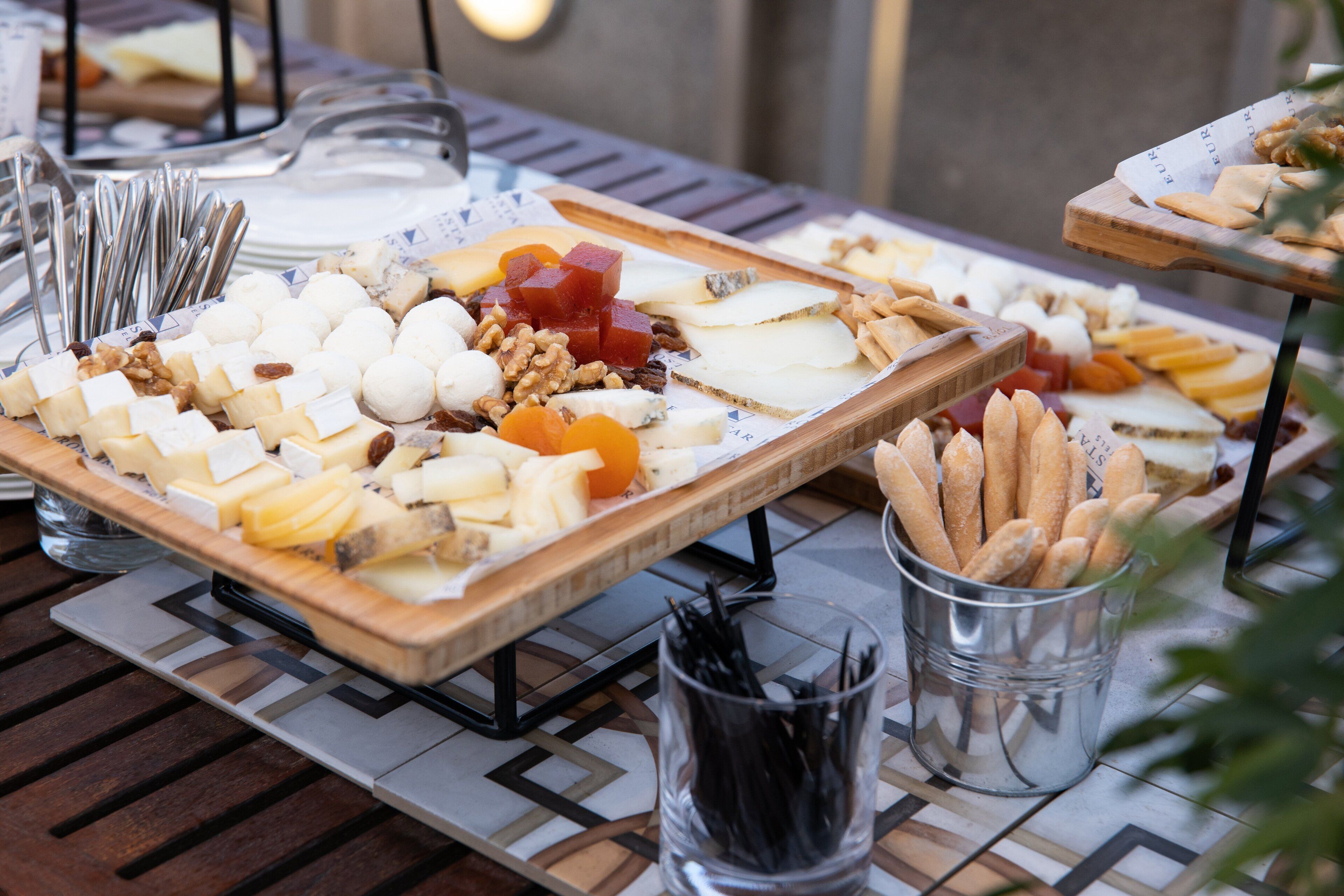 Ein Tisch mit verschiedenen Käsesorten, Nüssen und Brot.