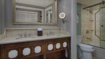 A bathroom with a double sink vanity, a mirror, a round light, and a shower area.