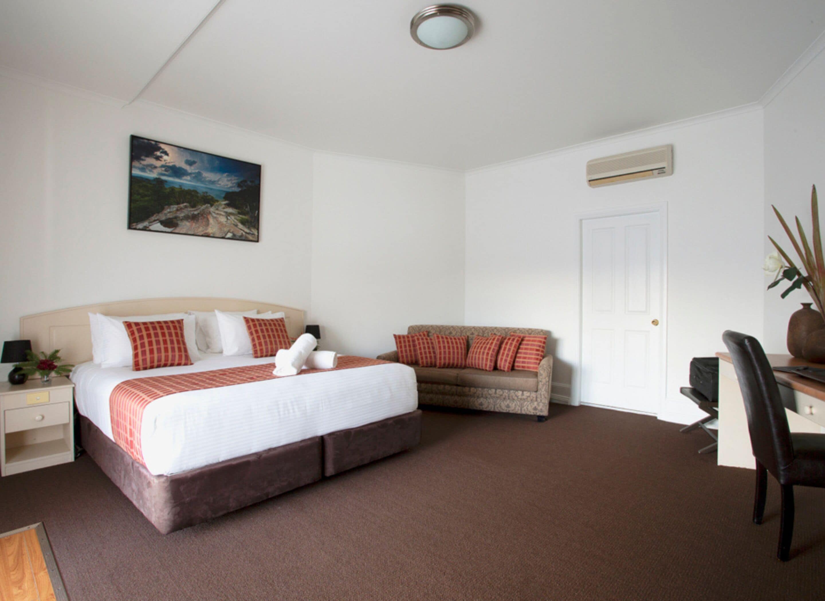 Une chambre à coucher avec un lit, un canapé, un bureau et une chaise.