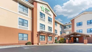 A multi-story hotel with a prominent Stay America sign, a lobby entrance, and a parking lot. - Extended Stay America Suites Sacramento Vacaville (Vacaville)