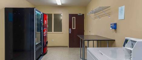 Una sala de lavandería con lavadora, secadora y refrigerador.