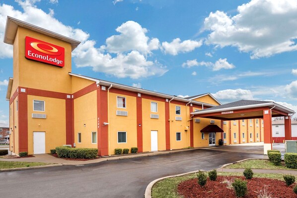 A hotel with a yellow facade, a red logo, and a covered entrance. - Econo Lodge Louisville Airport (Louisville)