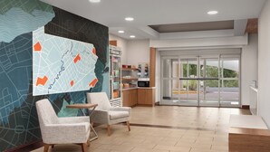 A lobby with a map mural, seating area, kitchenette, and a view through the glass doors. - Holiday Inn Express Hotel & Suites Chambersburg by IHG (Chambersburg)