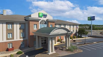 A Holiday Inn Express hotel with a covered entrance, brick facade, and a parking lot.