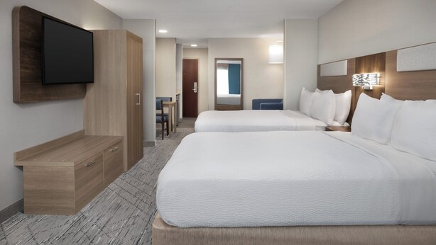 A hotel room with two beds, a TV mounted on the wall, a desk, and a chair. - Holiday Inn Express Hotel & Suites Chambersburg by IHG (Chambersburg)