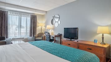 Une chambre d’hôtel équipée d’un lit, d’un bureau, d’une chaise, d’une télévision et de deux lampes.