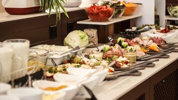Uma mesa de buffet com diversos alimentos e utensílios.