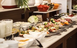 A buffet table with various food items and utensils. - President Hotel (Kyiv)