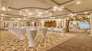A banquet hall with round tables, white drapery, and a patterned carpet. - President Hotel (Kyiv)