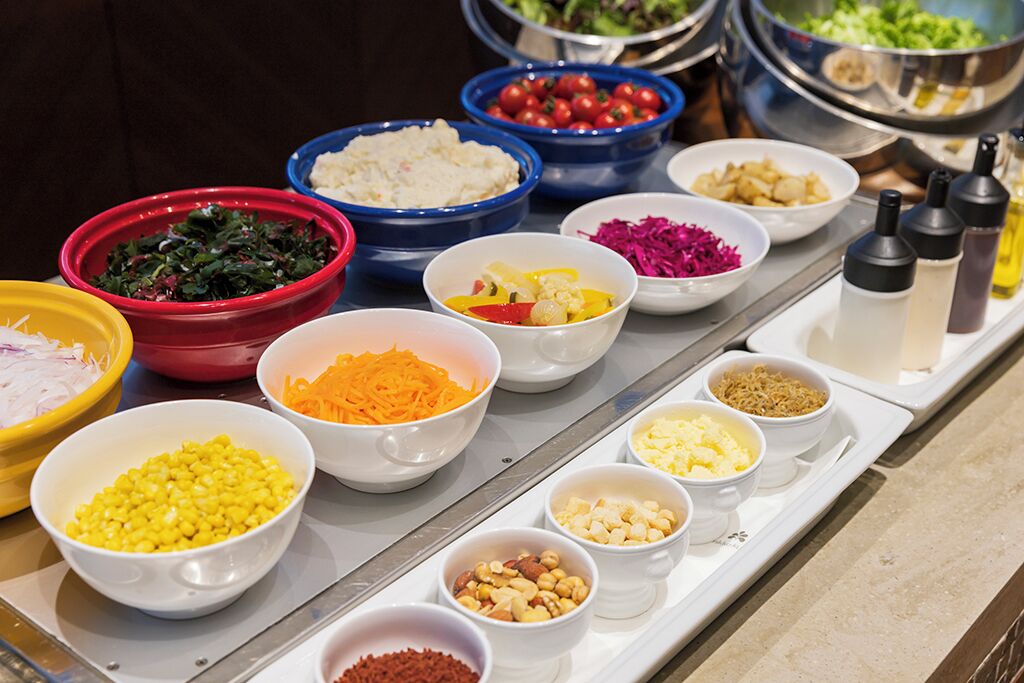 A buffet table with various food items in bowls.