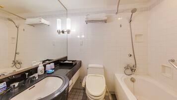 A modern bathroom with a large sink, toilet, and bathtub.