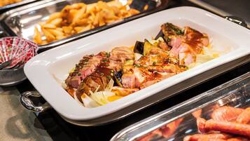 A buffet with various dishes including sliced meat and potatoes.