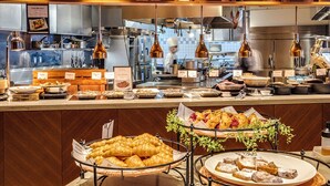 A buffet area with various food items, including pastries and bread, displayed on tables and in baskets. - Hotel Nikko Kumamoto (Kumamoto)