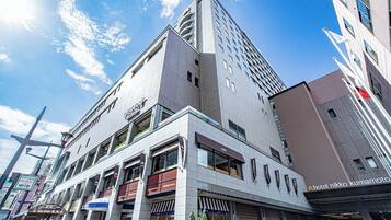 Un hôtel moderne doté d’une entrée imposante, de plusieurs étages et offrant une vue dégagée sur le ciel.