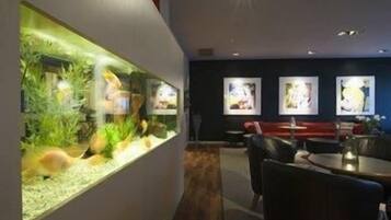 A modern interior with a fish tank, seating area, and artwork on the walls.
