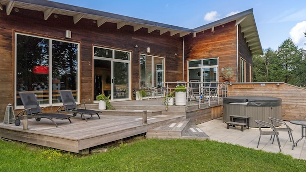 A modern house with a wooden deck, outdoor seating, and a hot tub. - Best Western Hotel Norra Vattern (Askersund)
