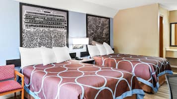 A hotel room with two beds, a desk, a chair, and a large window with a view of a building.