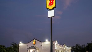 A Super 8 hotel with a prominent sign, a parking lot, and a building facade.