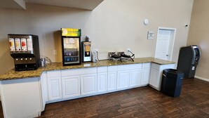 A kitchen with a granite countertop, white cabinets, a coffee machine, a refrigerator, and a trash can. - Econo lodge Flagstaff East I-40 (Flagstaff)