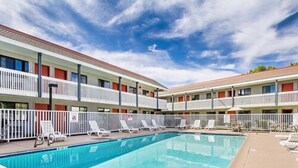 A hotel with a swimming pool, multiple balconies, and lounge chairs. - Econo lodge Flagstaff East I-40 (Flagstaff)