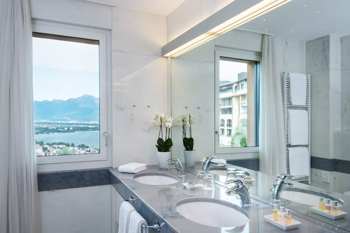 panorama corner suite, lake view | bathroom | deep-soaking bathtub, designer toiletries, hair dryer, dressing gowns