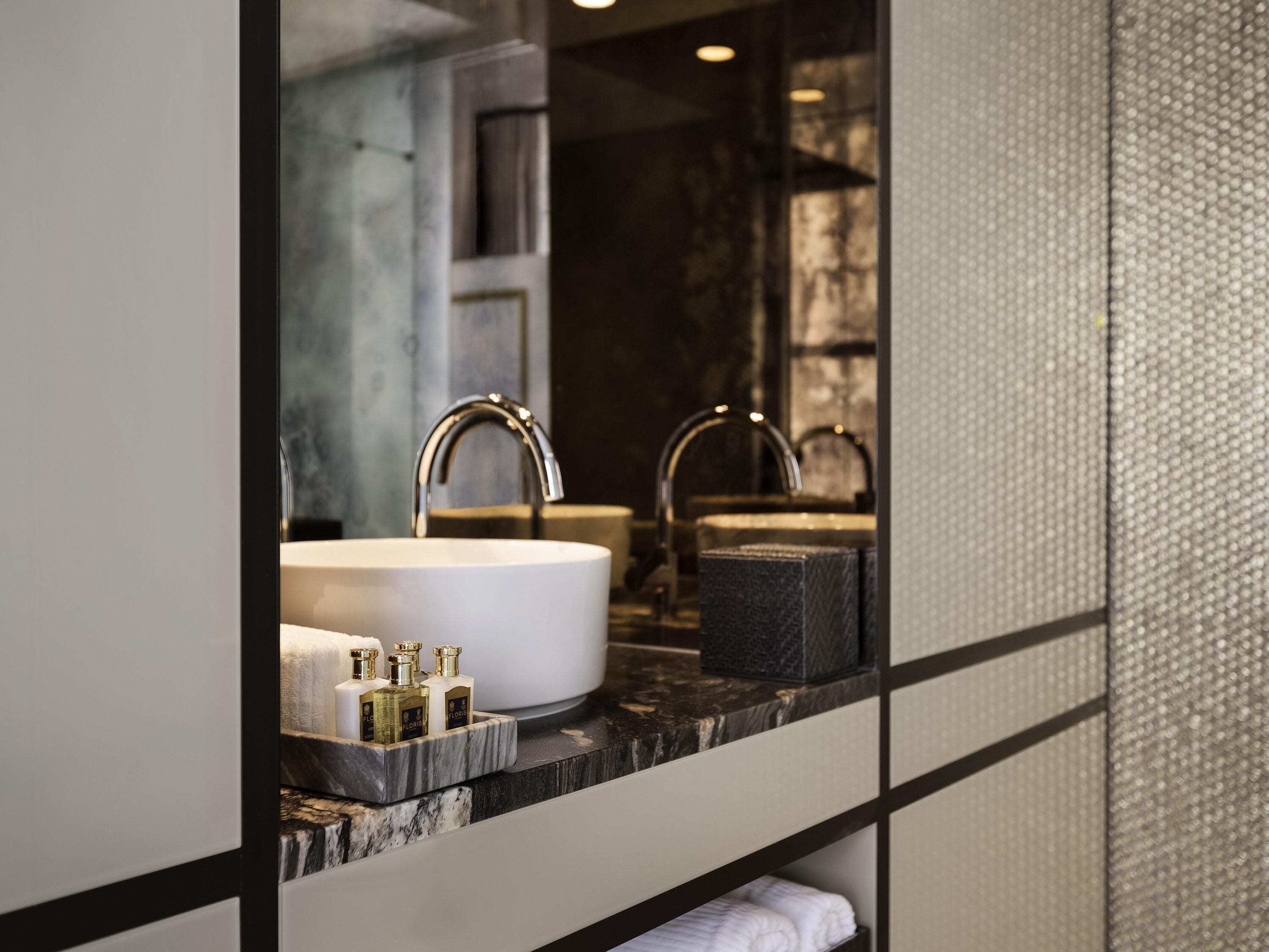 A bathroom with a large mirror, two sinks, and a marble countertop.