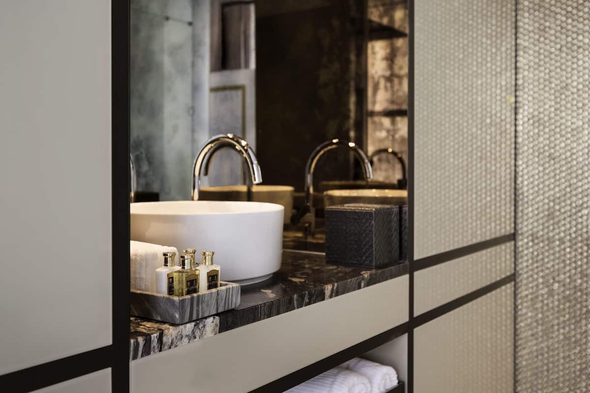 A bathroom with a large mirror, two sinks, and a marble countertop.