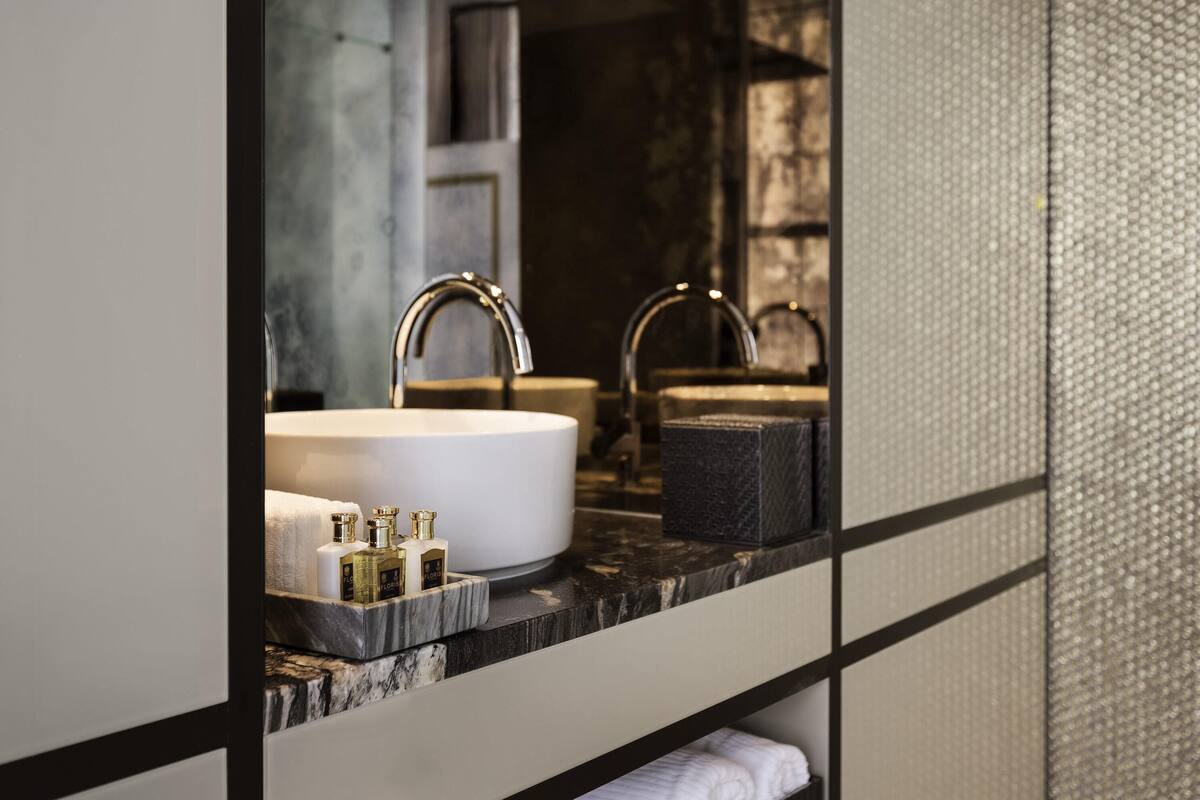 A bathroom with a large mirror, two sinks, and a marble countertop.