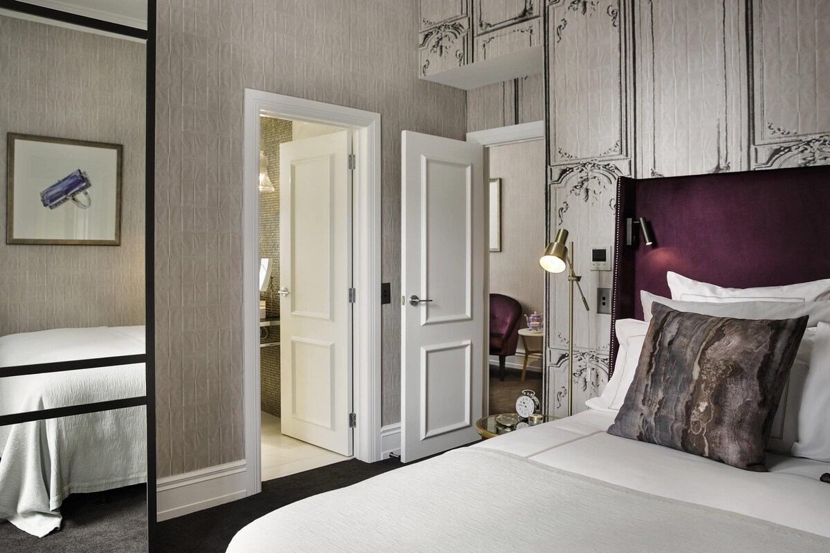 Une chambre d’hôtel avec un lit, une table de chevet, une lampe et une armoire.