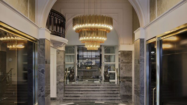 A grand lobby with a checkered floor, large chandeliers, and marble walls. - Fable Auckland, MGallery (Auckland)