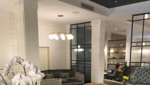 A modern lounge area with a marble table, plush armchairs, and a decorative orchid plant. - Fable Auckland, MGallery (Auckland)