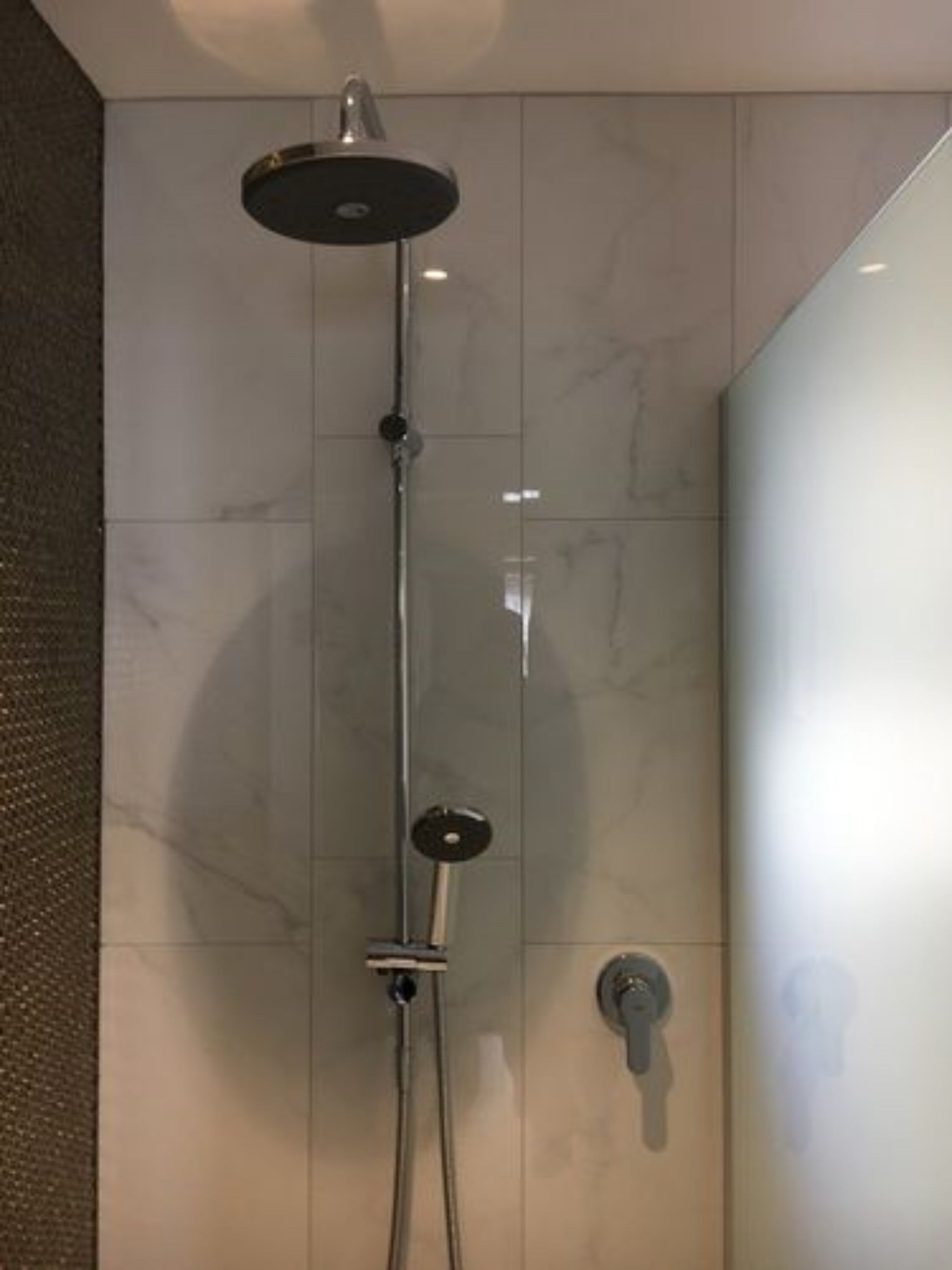 A modern bathroom with a shower, a toilet, and a sink.