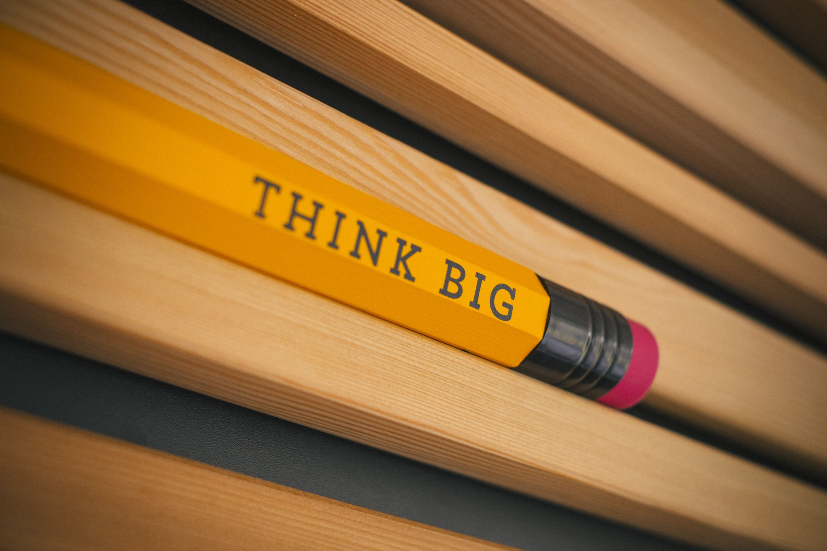A yellow pencil with the words "THINK BIG" written on it.