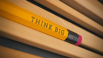 A yellow pencil with the words "THINK BIG" written on it.