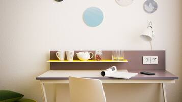 A modern room with a desk, chair, and a shelf with cups and a lamp.