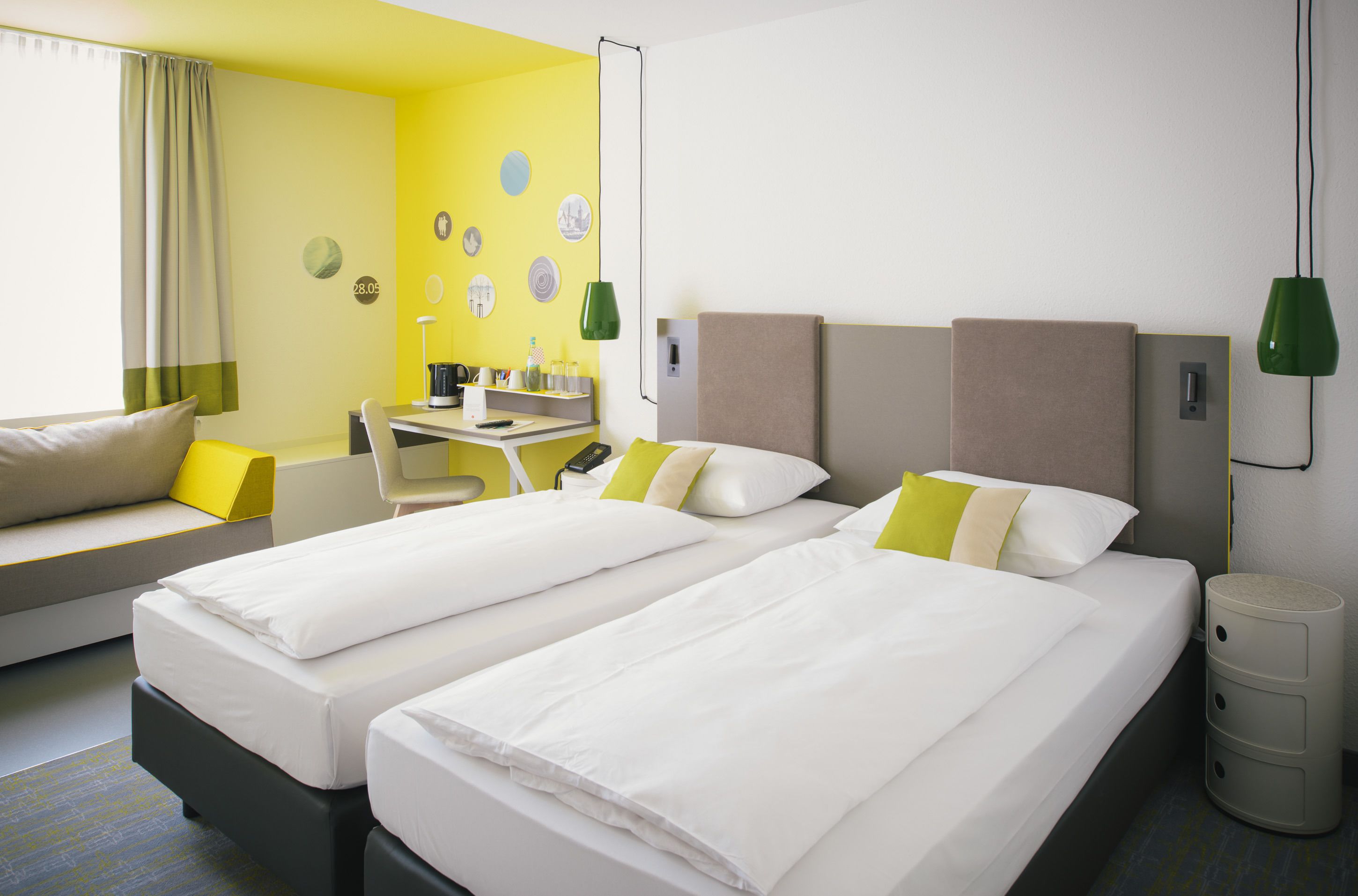 Habitación de hotel con dos camas, un sofá, un escritorio y una mesita.