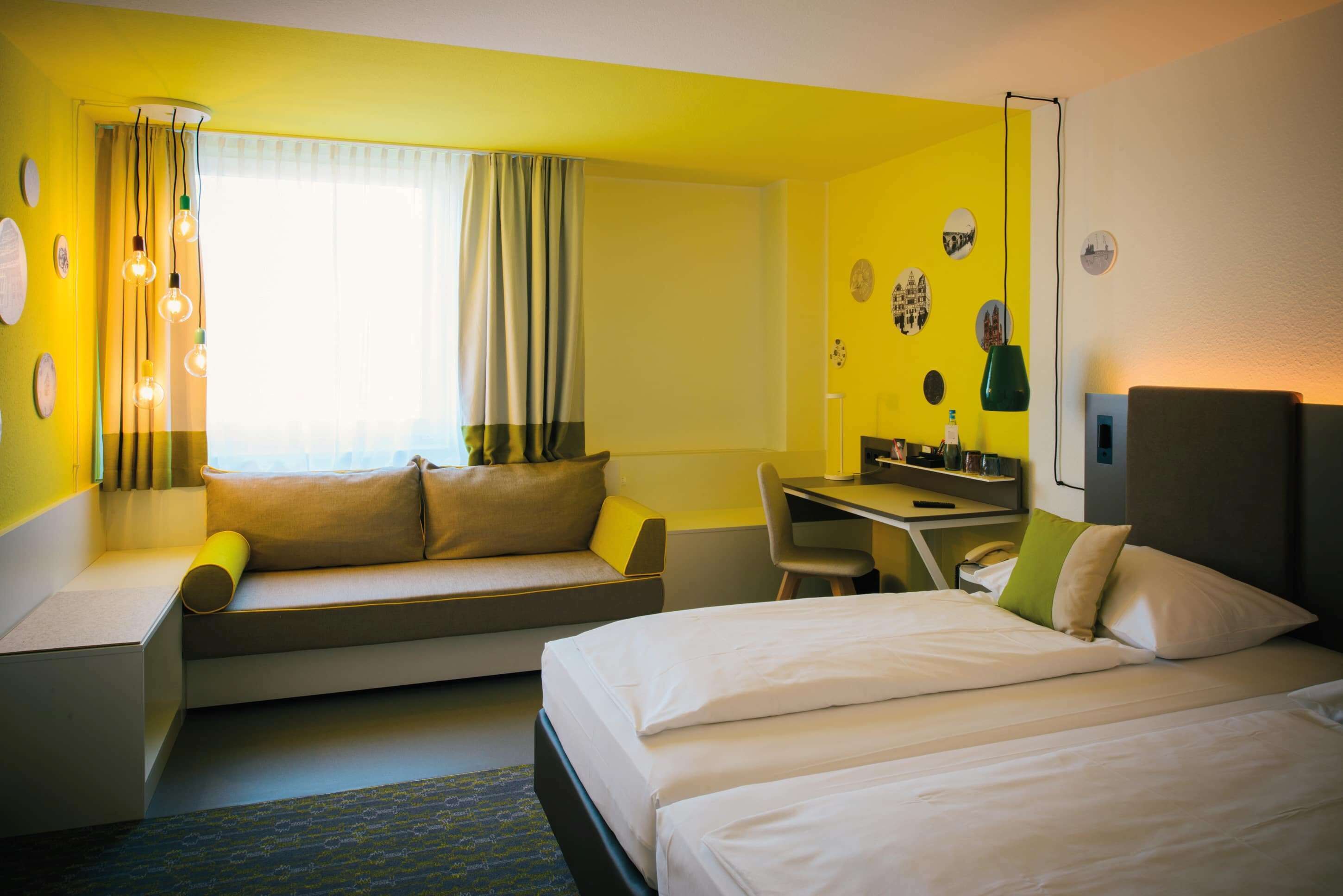 Una habitación de hotel con cama, sofá, escritorio y una silla.