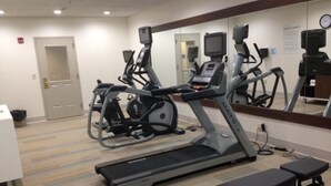 A gym with treadmills, an elliptical, and a bench. - Holiday Inn Express and Suites Pigeon Forge Sevierville by IHG (Sevierville)