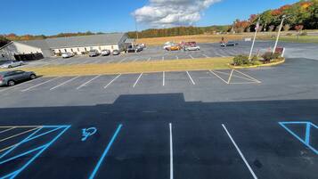 Un estacionamiento con espacios reservados para discapacitados y un edificio al fondo.