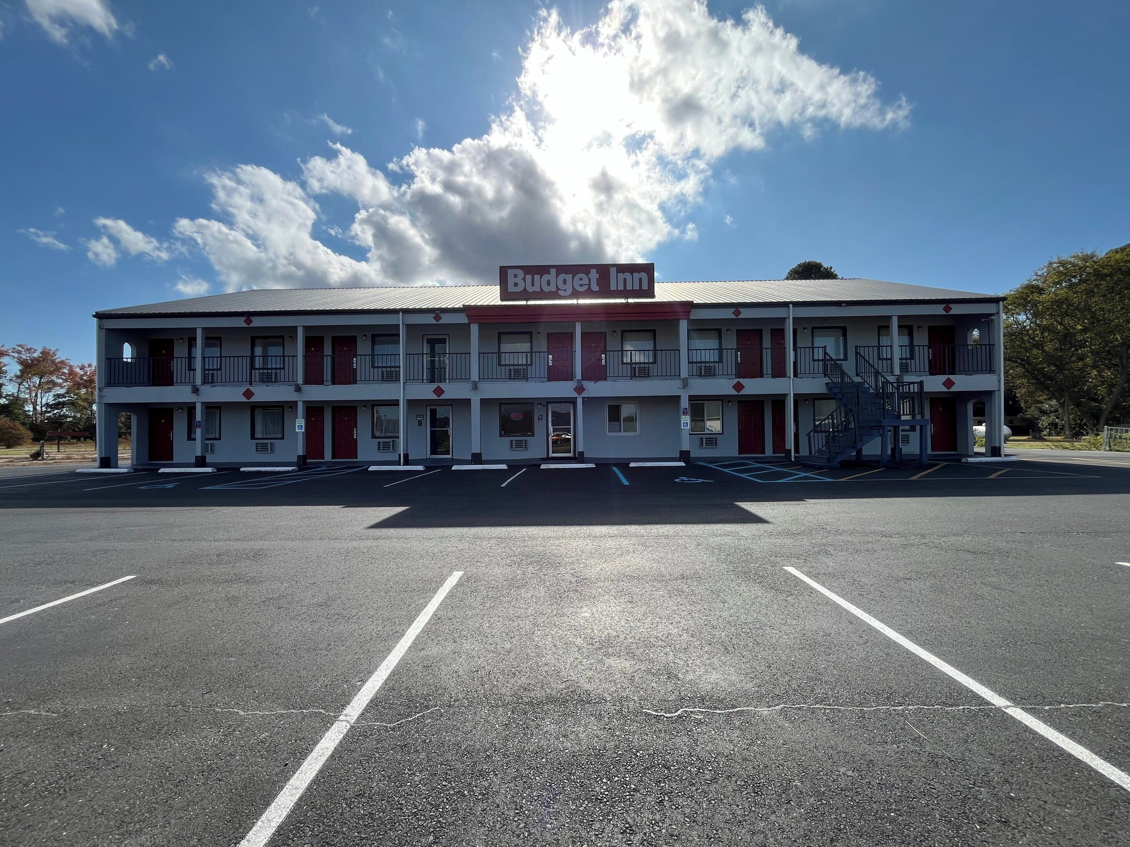 Een Budget Inn met twee verdiepingen en een parkeerplaats ervoor.