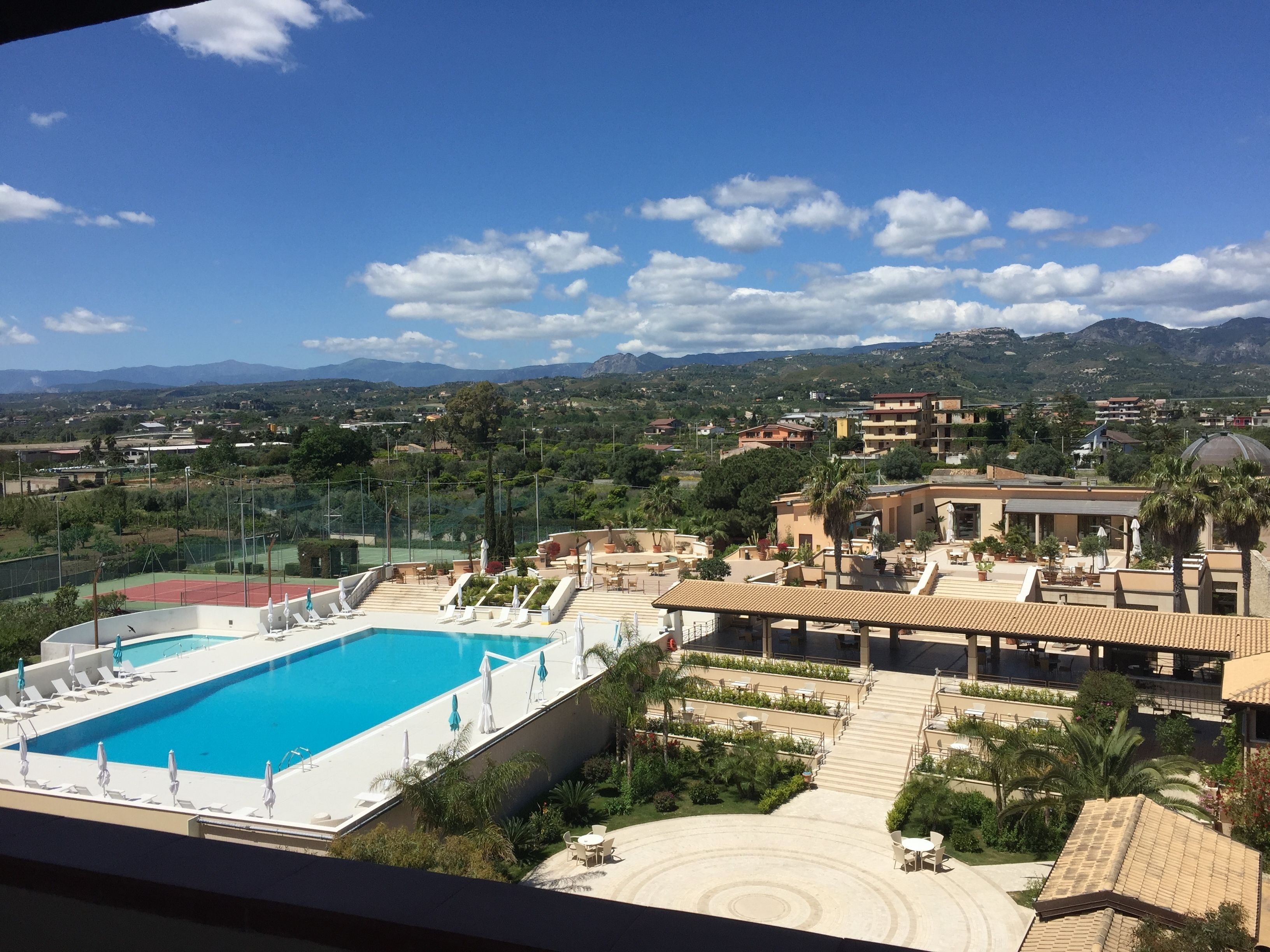 Un resort con piscina, mobiliario exterior y vistas del paisaje circundante.
