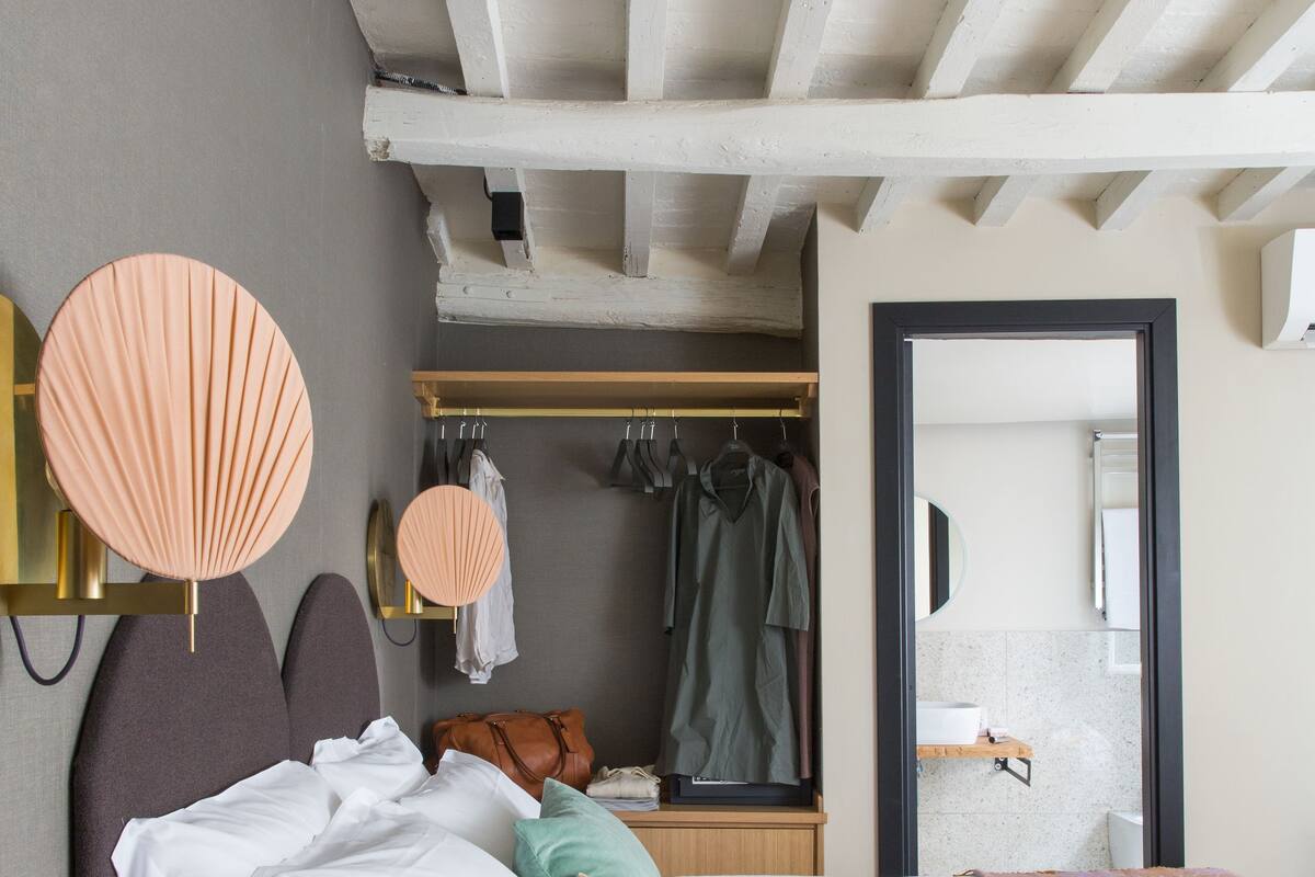 A bedroom with a bed, bedside tables, a wardrobe, and a mirror.