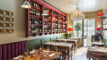 Un restaurant doté d’une cave à vin, de tables en bois et d’un lustre.
